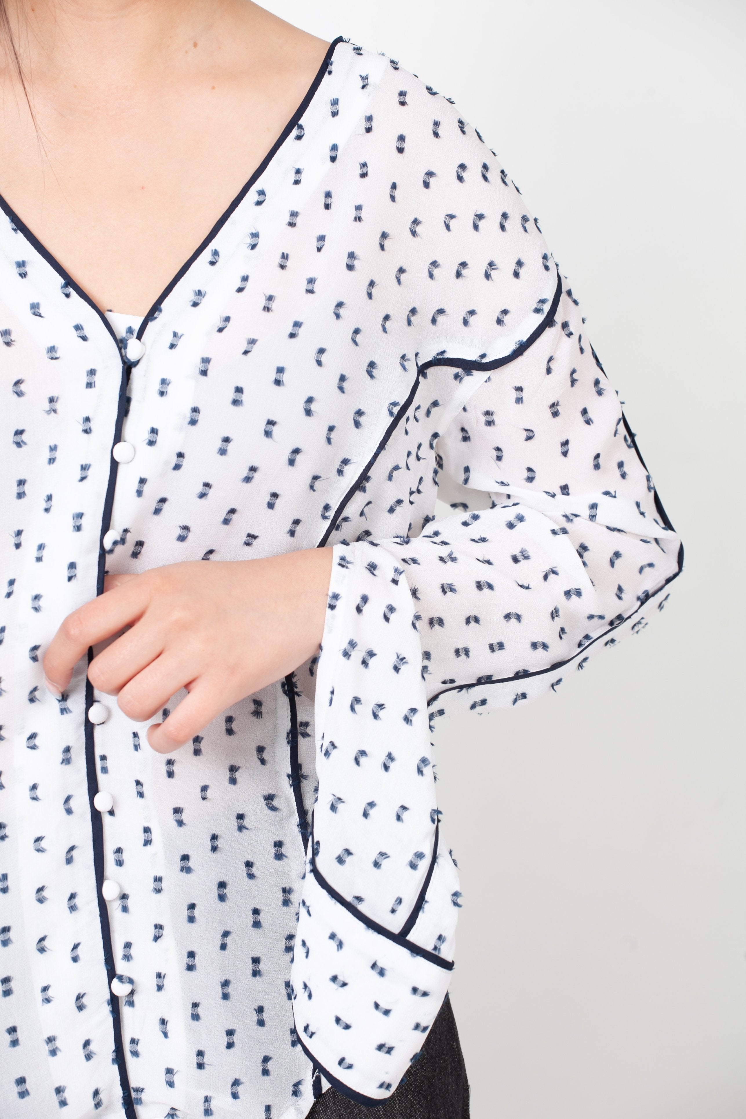 blusa con botoenes delanteros y manga abierta blanca y negra